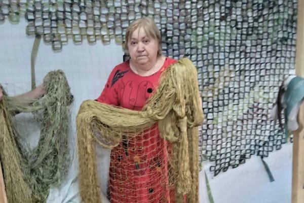 Волонтери фонду «Червона Калина Харків» плетуть маскувальні сітки для українських захисників.