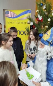 Святий Миколай спілкується з дітьми-переселенцями, заспокоює їх і милується їхніми щирими малюнками.